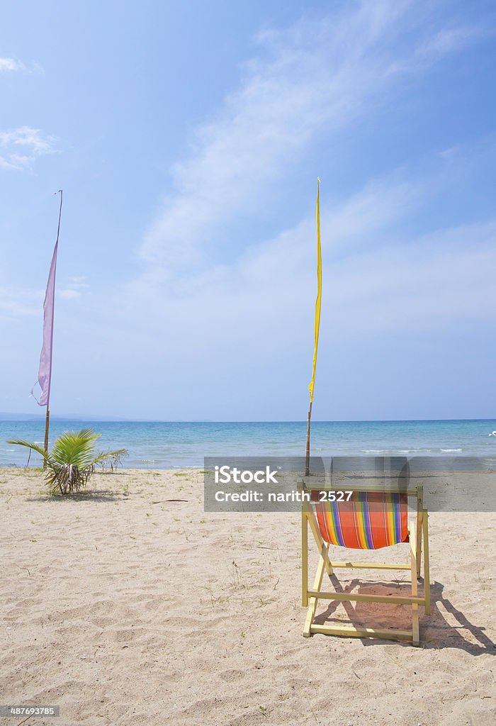 Beach chairs on the white sand beach Beach chairs on the white sand beach with cloudy blue sky Beach Stock Photo