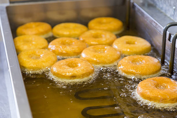 istock fried equal round doughnuts in deep-fryer 487695134