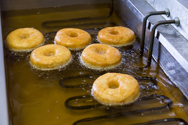 istock fried equal round doughnuts in deep-fryer 487695174
