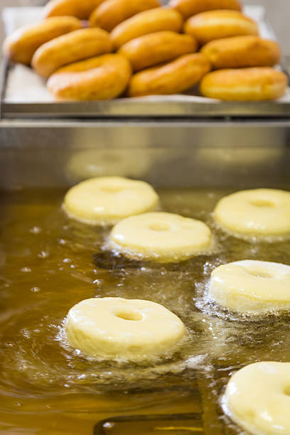 istock fried equal round doughnuts in deep-fryer 487695222