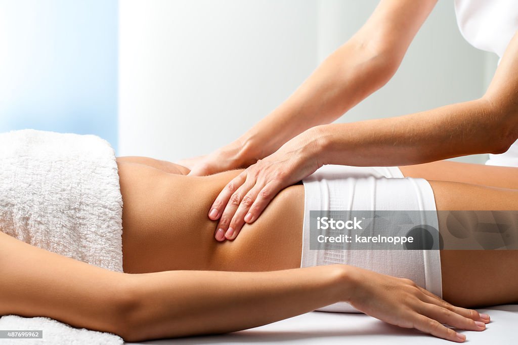 Therapist doing curative belly massage on female patient. Close up of osteopath doing manipulative abdomen massage on female patient. Limbic System Stock Photo