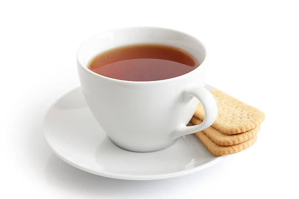 istock White ceramic cup and saucer with tea and finger biscuits. 487702972