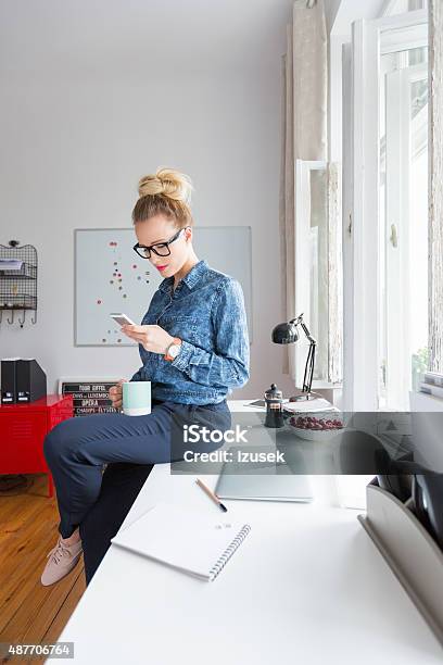 Woman Texting On Smart Phone In An Office Stock Photo - Download Image Now - 2015, Adult, Adults Only