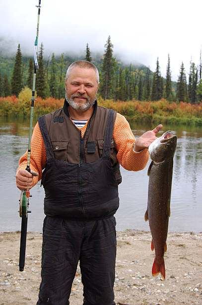 istock Fisherman caught a small taimen. 487708022