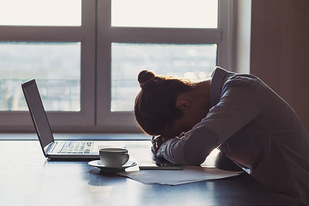 Tired woman in the office Silhouette of stressed businesswoman in the office defeat photos stock pictures, royalty-free photos & images