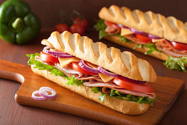 long baguette sandwich with ham cheese tomato lettuce