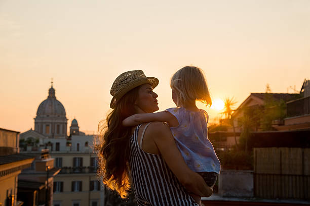 istock Mother holding daughter in her arms overlooking Rome 487719042