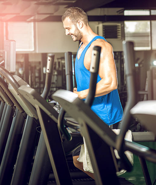 istock Young man running at treadmill in gym 487719192