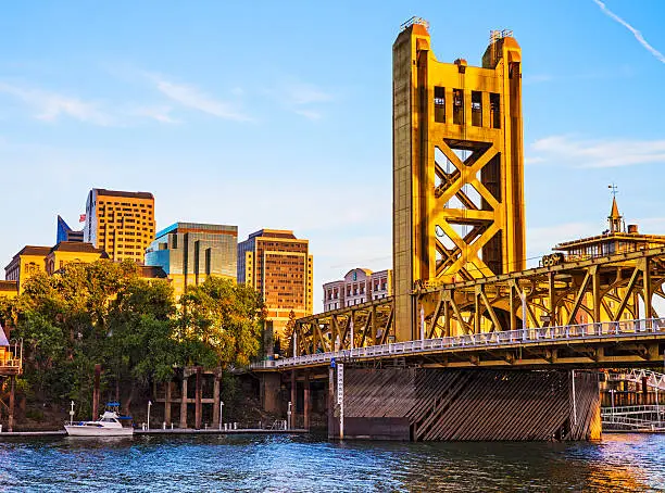 The buildings of downtown Sacramento California and the Tower Bridge illuminated by warm evening light. 