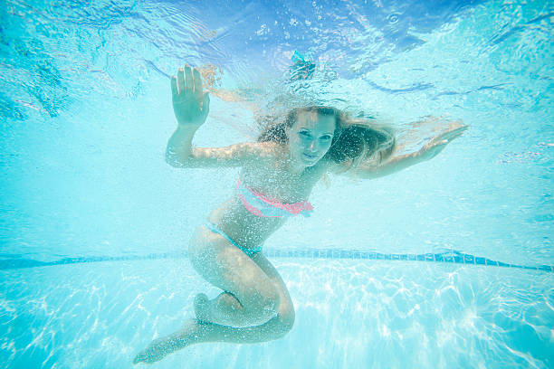 istock Young woman swimming underwater 487721648