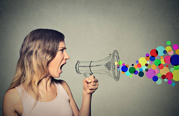 istock angry screaming young woman holding megaphone 487721838