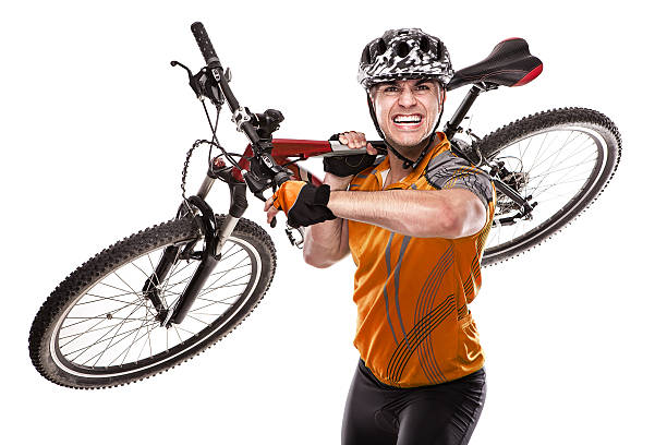 Active young biker isolated on white background. Young man riding and jumping on back wheel of mountain bicycle. Extreme sport