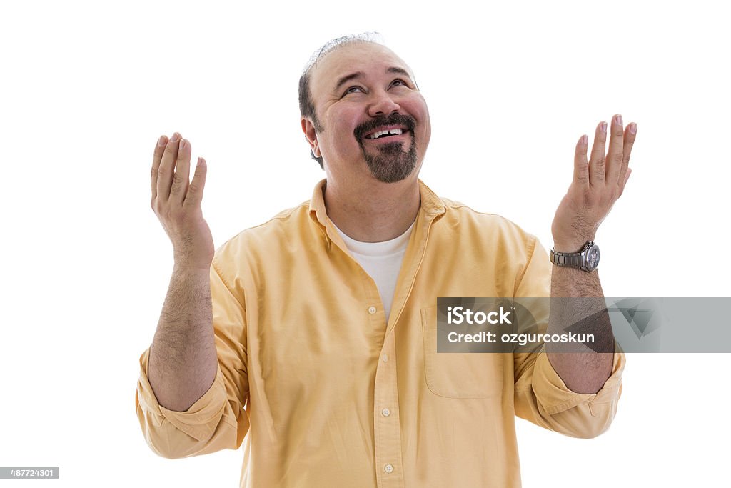 Man giving thanks to God for a successful outcome Happy middle-aged man giving thanks to God for a successful outcome smiling and raising his hands with a smile in thanksgiving, part of a series on body language, isolated on white Gratitude Stock Photo