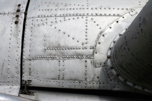 Aircraft fuselage and wing with rivets.