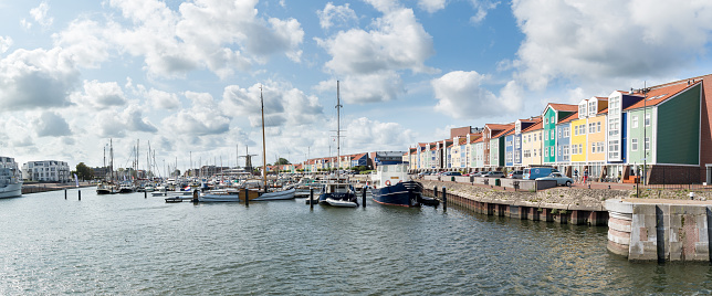 Hellevoetsluis, Netherlands - August 25, 2015: Panorama of harbour with windmill and colorful wharf houses in the city of Hellevoetsluis, Netherlands