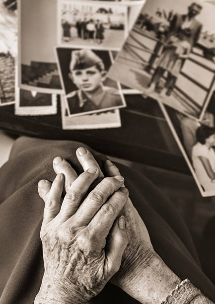 istock Senior woman's hands in front of dear photographs 487726917