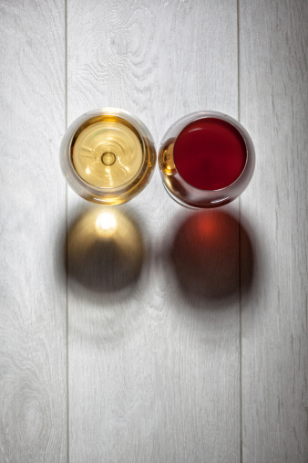Glasses of red and white wine on wooden table