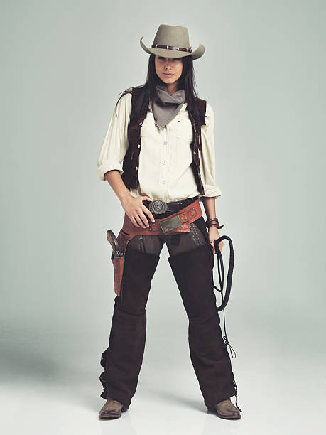 She'll have you whipped in the blink of an eye An attractive cowgirl standing isolated on gray while holding a whip cowgirl stock pictures, royalty-free photos & images