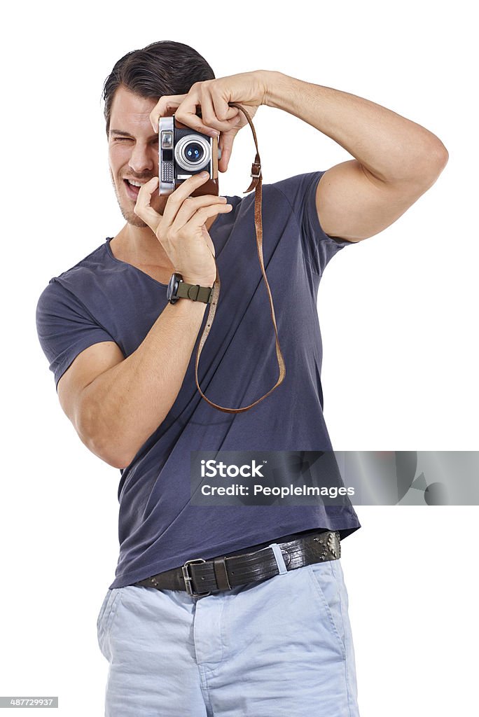 Getting into photography Studio portrait of a handsome young man holding a retro camera isolated on white Camera - Photographic Equipment Stock Photo