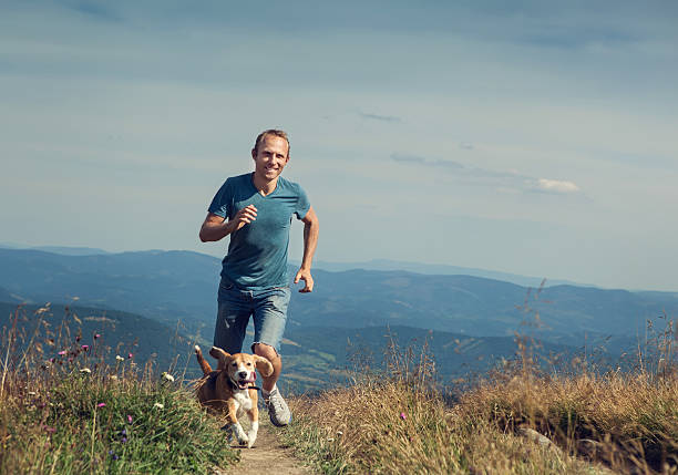 istock Man running with his dog on the mountain tableland. 487732234