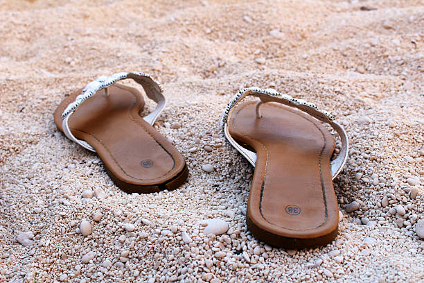 Nice ladies sandals on the sandy beach stock photo