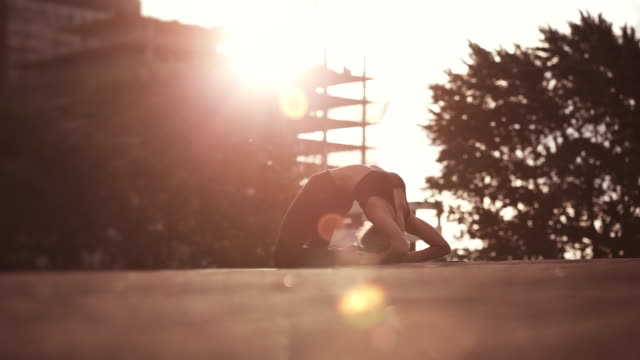 Young woman doing yoga meditating outdoors on a rooftop