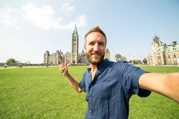 istock Young man taking selfie portrait at Ottawa parliament 487740882