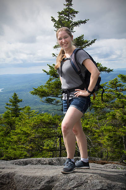 jeune femme avec un sac à dos de randonnée, le mont kearsarge sommet, nouveau hamp - hiking young women outdoors t shirt photos et images de collection