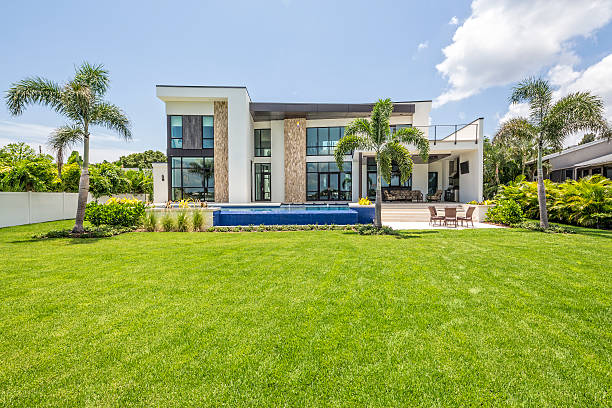 Beautiful Landscaped Modern Home with Swimming Pool and Sitting Area A beautiful modern home with landscaped backyard, swimming pool with waterfall and spa including an outdoor sitting area with TV. model home photos stock pictures, royalty-free photos & images