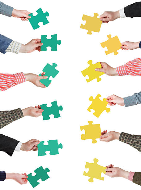 istock green and yellow puzzle pieces in people hands 487745887