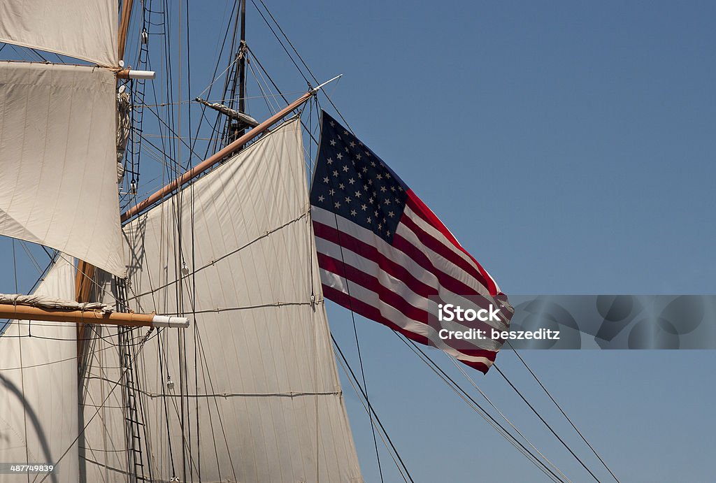 Sails with US flag Sails and rigging from an old ship with US flag flying in the wind. American Flag Stock Photo