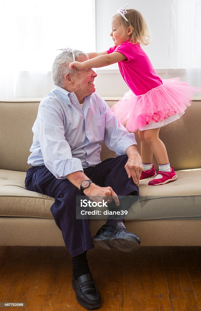 Grandfather and Granddaughter Play Dress up A grandfather and his granddaughter playing dress up together. Grandfather Stock Photo