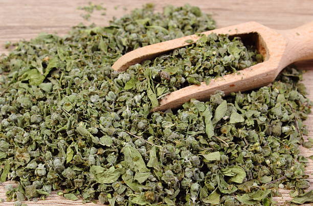 istock Dried marjoram with spoon on wooden background 487752540