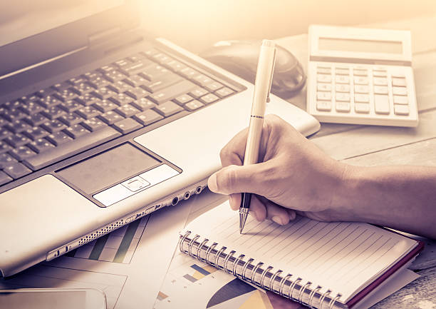 istock Busy business woman hand holding pen and writing on notebook 487755658