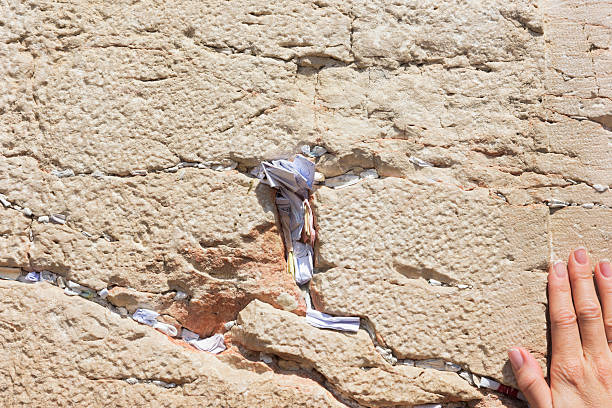 istock Womans hand prays on Jerusalem's Western Wall 487760476