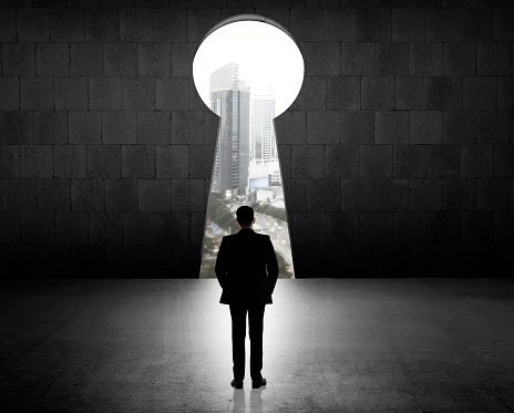 Concept of success business man looking through key hole