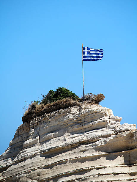 Greece flag on the cliff at the sea stock photo