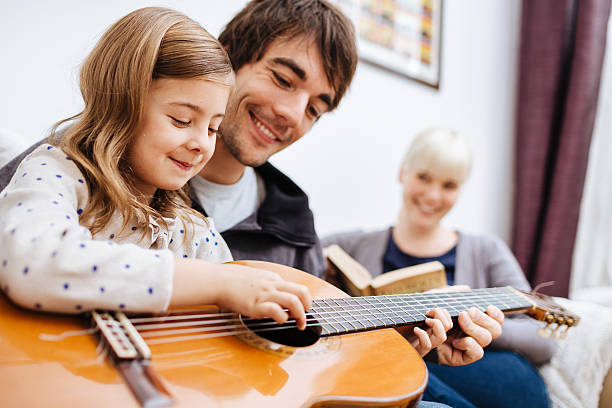 istock Father Teaching Daughter Guitar 487773867