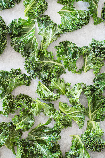 istock Seasoned leaves of curly kale arranged on the baking sheet 487774384
