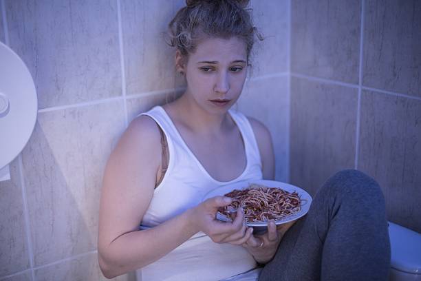 грустный девушка overeating - emaciated weight scale dieting overweight стоковые фото и изображения