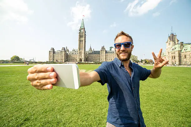 Photo of Cheerful young man taking selfie in Ottawa