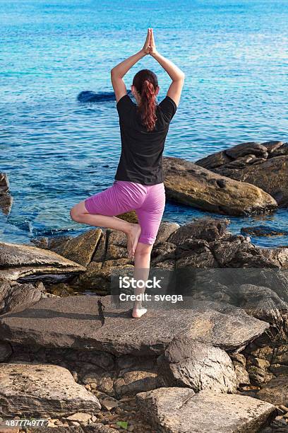 Woman Doing Yoga On A Rock Near Ocean Stock Photo - Download Image Now - Active Lifestyle, Adult, Adults Only