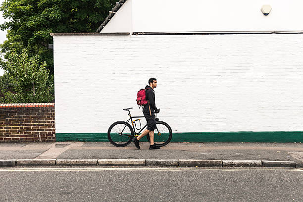 istock Commuter walking with bicycle in London streets 487775090