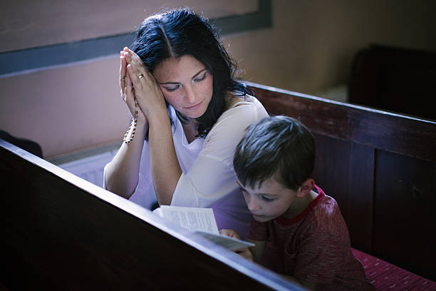 istock Woman with her son praying 487777672