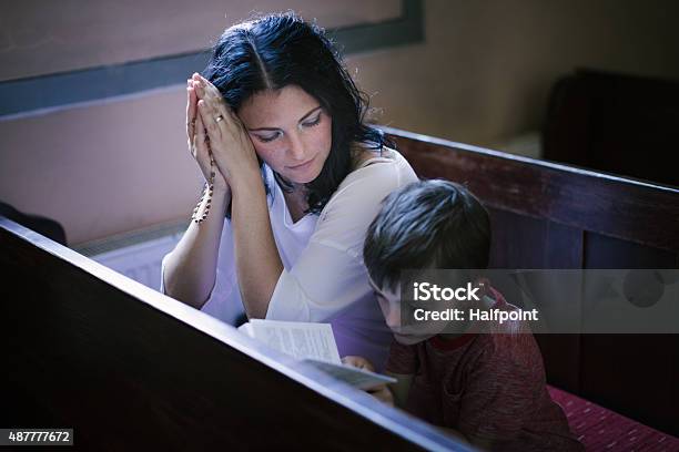 Woman With Her Son Praying Stock Photo - Download Image Now - Church, Child, Catholicism