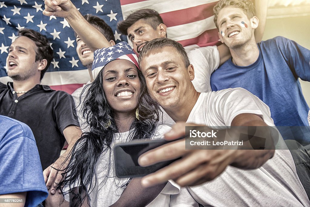 Jeune couple prenant un selfie sur le stade - Photo de Fan libre de droits
