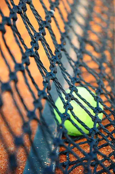 Tennis ball on a tennis clay court (Focus on net)