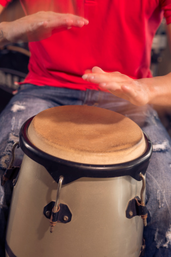 Man playing Cuban drum by his hands