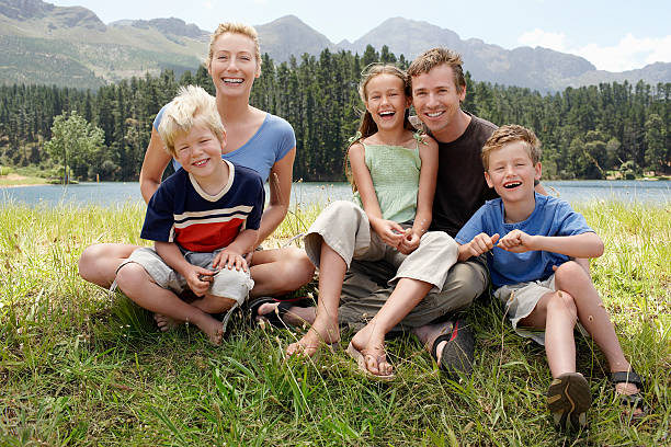 istock Happy Family Sitting On Grassy Field 487786853