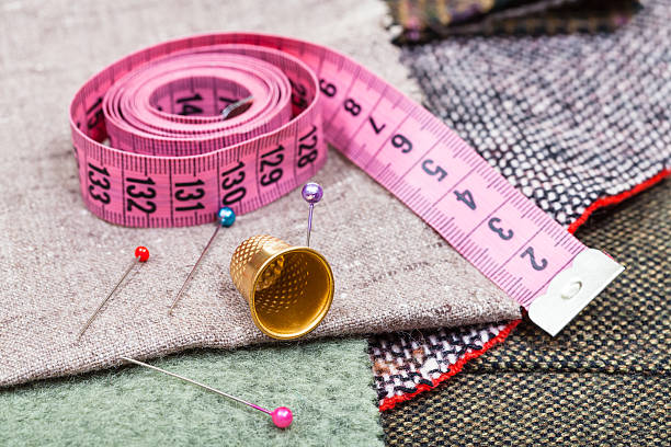 medida de fita rosa, cavilhas, dedal sobre têxteis - thimble sewing item close up studio shot imagens e fotografias de stock